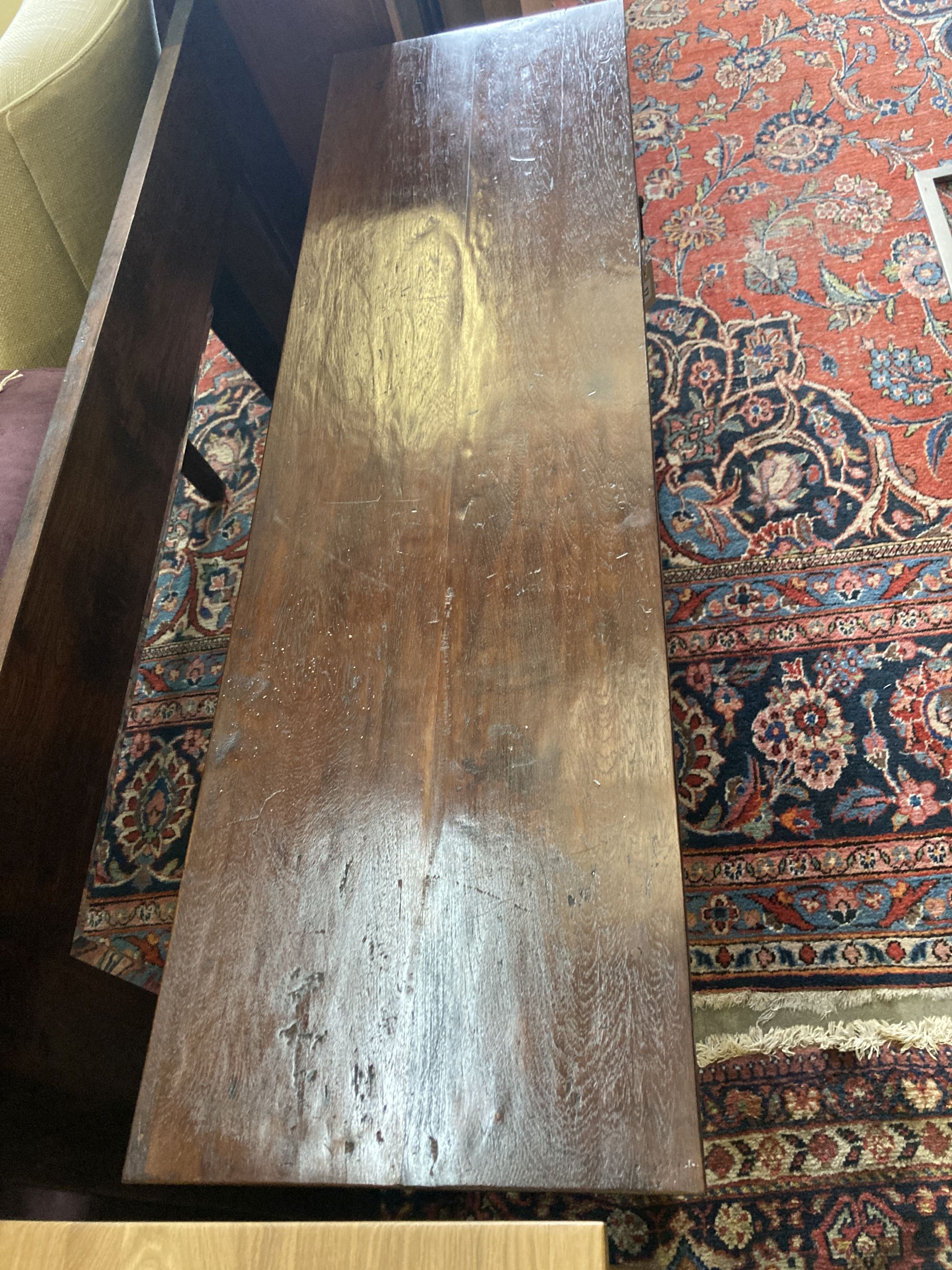 An Indian hardwood table, width 140cm, depth 40cm, height 76cm and a matching wall mirror